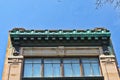 Blue-green cornice on old building against a blue sky.