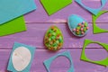 Blue and green felt Easter eggs, felt scrap and sheets, paper template on the purple wooden background. Easy Easter crafts