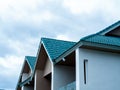 Blue green gable roof of the big modern white house building on blue sky background with copy space. Royalty Free Stock Photo