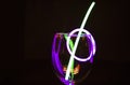 Blue and green glow stick on a wine glass and colourful light reflection aginst the dark background party photography