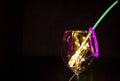 Blue and green glow stick on a wine glass with new year celebration with colorful light relection aginst the dark background party