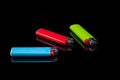 blue, green and red gas lighters on an isolated black background with reflection Royalty Free Stock Photo