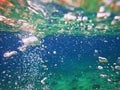 Blue green sea with bubbles above