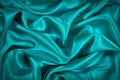 Blue and green silk satin fabric. Elegant teal color background. Liquid wave or silk soft wavy folds.