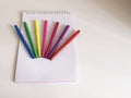 Colored felt-tip pens stand on a sketchbook