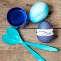 Blue greeting card with easter eggs, egg spoons and egg dyes, te Royalty Free Stock Photo