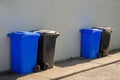 Blue and grey plastic wheelie bins out in a street ready for collection. Recycle industry concept. Disposal of household waste