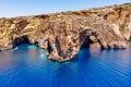 Blue Grotto in Malta. Pleasure boat with tourists runs. Natural arch window in the rock. Aerial top view. Royalty Free Stock Photo