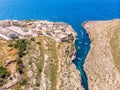 Blue Grotto in Malta. Pleasure boat with tourists runs. Natural arch window in rock. Aerial top view. Royalty Free Stock Photo