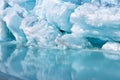 Blue growler piece of iceberg with reflection in calm water. Arctic ocean Royalty Free Stock Photo