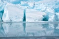 Blue growler piece of iceberg with reflection in calm water. Arctic ocean Royalty Free Stock Photo