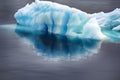 Blue growler (piece of iceberg) with reflection in calm water Royalty Free Stock Photo