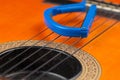 Blue guitar capo and guitar isolated on white background Royalty Free Stock Photo