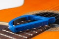 Blue guitar capo and guitar on white background