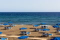Blue hammocks and umbrellas on empty beach in Puerto del Carmen