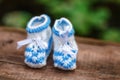 Blue hand made crochet baby booties on wooden background, closeup Royalty Free Stock Photo