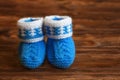 Blue hand made crochet baby booties on wooden background, copyspace Royalty Free Stock Photo