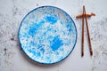 Blue hand painted ceramic serving plate with wooden chopsticks on side Royalty Free Stock Photo