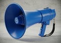 A blue handheld megaphone on a gray background Royalty Free Stock Photo