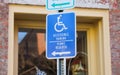 Blue handicap sign on the street - a symbol for mobility aid for people with disabilities Royalty Free Stock Photo