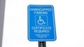 Blue handicap sign on the street - a symbol for mobility aid for people with disabilities Royalty Free Stock Photo