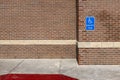 Blue handicapped parking sign on a red brick wall of an office building in the United Sates of America Royalty Free Stock Photo