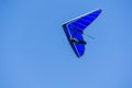 Blue hang glider against blue sky