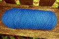 A blue hank of woolen threads on a gray board of a bench