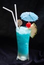 Blue Hawaii cocktail Tall glass with umbrella with pineapple and red cherries.Suitable for drinking for refreshing, quenching Royalty Free Stock Photo