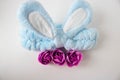 A blue headband with rabbit ears and pink soap roses. Body care. Easter Concept