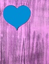 The blue heart is carved in a wooden board of purple. Background. Royalty Free Stock Photo