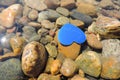 Blue heart floating on  river water , stones backgrounds, selective focus Royalty Free Stock Photo