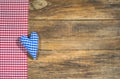 Blue heart and red checkered fabric on rustic wooden board. Royalty Free Stock Photo