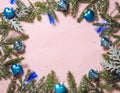 Blue heart shape Christmas ornaments with blue led party lights on pastel pink background  decorated with fir tree branches. Royalty Free Stock Photo