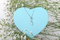 Blue heart shape gift box on a white backround with small withe flowers Royalty Free Stock Photo