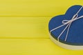 Blue heart-shaped gift box on yellow wood. Royalty Free Stock Photo