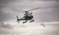 Blue helicopter in flight over gray sky Royalty Free Stock Photo