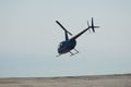 Blue helicopter flying in grey cloudy skies Royalty Free Stock Photo