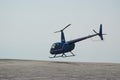 Blue helicopter flying in grey cloudy skies Royalty Free Stock Photo