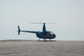 Blue helicopter flying in grey cloudy skies Royalty Free Stock Photo