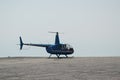 Blue helicopter flying in grey cloudy skies Royalty Free Stock Photo