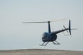 Blue helicopter flying in grey cloudy skies Royalty Free Stock Photo