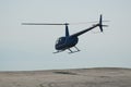 Blue helicopter flying in grey cloudy skies Royalty Free Stock Photo