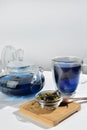 Blue herbal tea in a glass teapot on white background. Butterfly pea flower tea is brewed in teapot and served into a transparent Royalty Free Stock Photo