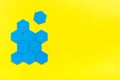 Blue hexagons form a beehive on a yellow background. One hexagon is separated from the figure. The concept of suspension