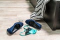 Blue high-heeled shoes, green-black lace thong panties and a condom on the wooden floor by the bed Royalty Free Stock Photo