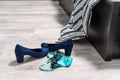 Blue high-heeled shoes, green-black lace thong panties and a condom on the wooden floor by the bed Royalty Free Stock Photo