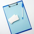 Blue holder with clean blue sheets, pen, empty business card on a white background Royalty Free Stock Photo