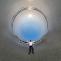 blue hole sphere little planet inside ocean seashore and sands withhappy man stands on coast in rays of evening tropical sun with