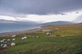 Beside the blue holy lake is a green prairie with many white houses